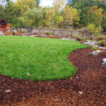 A green lawn in the middle of a garden.